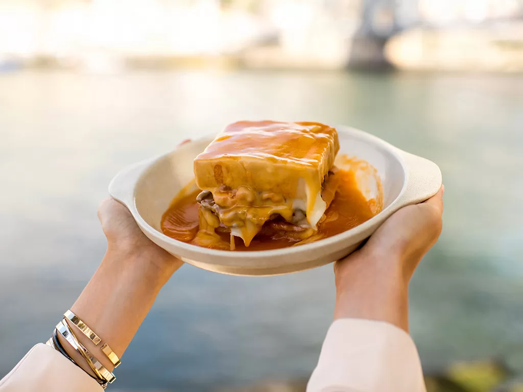 A gastronomia do Porto é uma verdadeira celebração de sabores intensos e autênticos, refletindo a rica história e a tradição desta cidade vibrante. Um dos pratos mais emblemáticos da cidade é o Francesinha, uma deliciosa sanduíche recheada com carne, coberta com queijo derretido e um saboroso molho à base de tomate e cerveja, servida com batatas fritas. Esta iguaria, que tem as suas raízes na influência da culinária francesa, conquistou corações e paladares e é imperdível para quem visita o Porto. Preço: Consultar